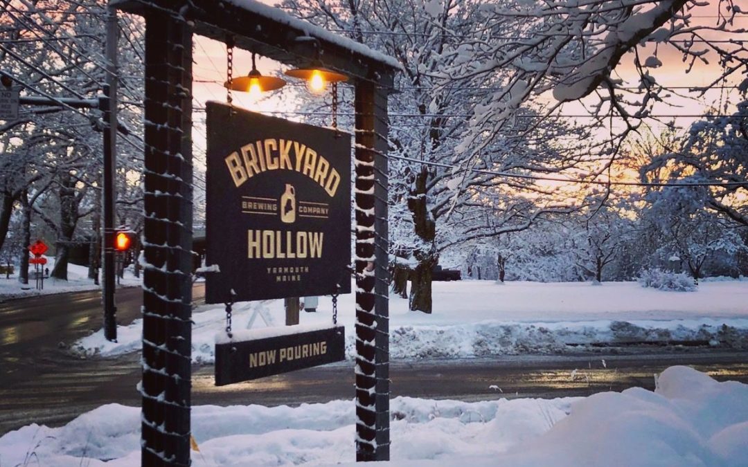Brickyard Hollow sign wrapped in Christmas lights and fresh snow around