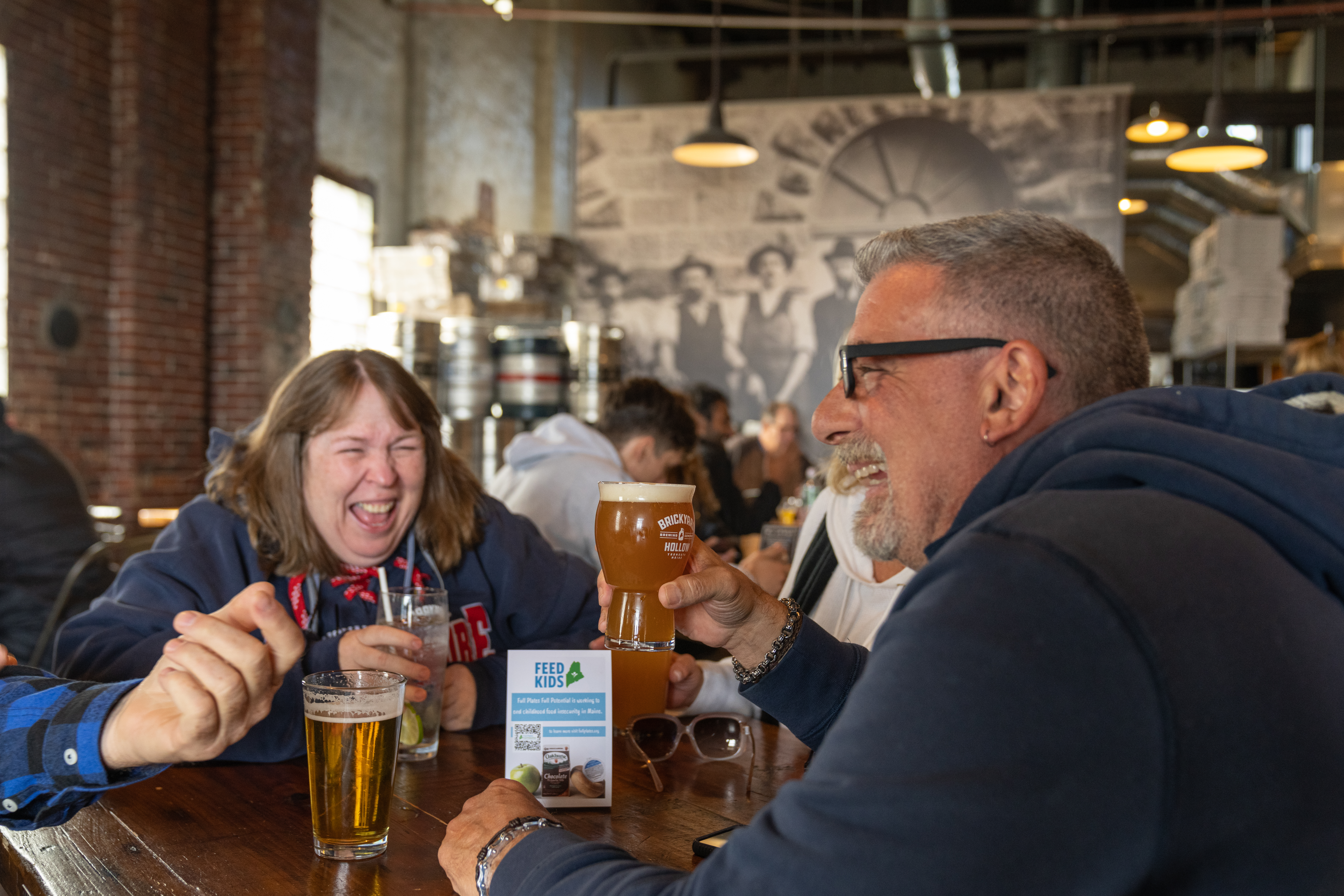 Group of people laughing and drinking Brickyard Hollow craft beer